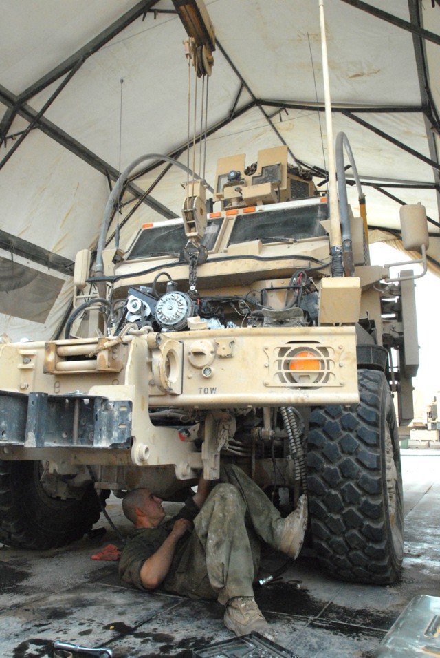 CAMP LIBERTY, Iraq - All-wheel mechanic, Spc. Catlynn Kovacs, from Colorado Springs, Colo., assigned to Headquarters Support Company, Division Special Troops Battalion, 1st Cavalry Division, works to install a new engine on a Mine-Resistant...