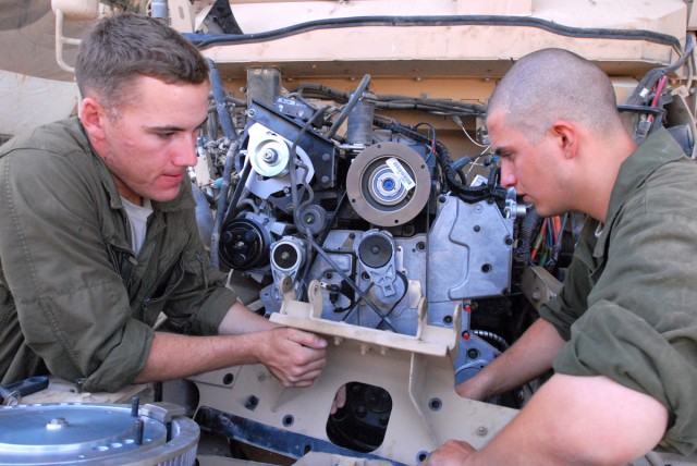 CAMP LIBERTY, Iraq - All-wheel vehicle mechanics, Spc. Harold Rust (left), from Helena, Mont. and Spc. Catlynn Kovacs (right), from Colorado Springs, Colo., both assigned to Headquarters Support Company, Division Special Troops Battalion, 1st...