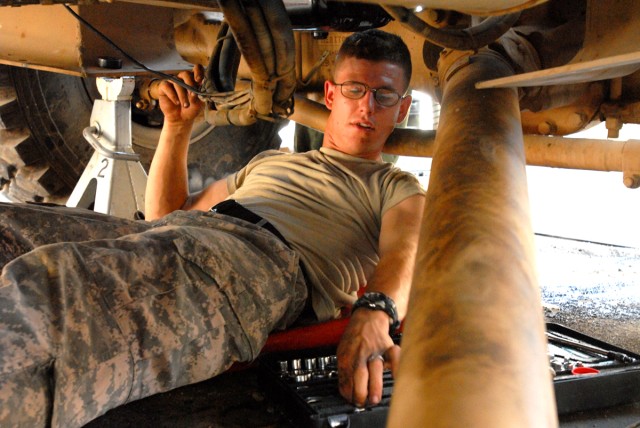 CAMP LIBERTY, Iraq - Spc. Joshua Tisdale, an all-wheel mechanic from Pekin, Ill., assigned to Headquarters Support Company, Division Special Troops Battalion, 1st Cavalry Division, hooks up wires to the starter, here, Sept. 9.  Disassembling and...