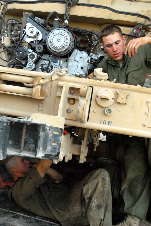 CAMP LIBERTY, Iraq - All-wheel mechanics, Spc. Catlynn Kovacs (bottom), from Colorado Springs, Colo., and Spc. Harold Rust (top), from Helena, Mont., both assigned to Headquarters Support Company, Division Special Troops Battalion, 1st Cavalry...