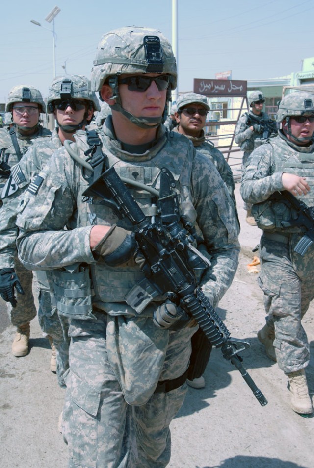 TAJI, Iraq- Quincy, Mass., native, Spc. Kellan Losi, a combat medic assigned to Headquarters and Headquarters Battery, 1st "Dragon" Battalion, 82nd Field Artillery Regiment, 1st Brigade Combat Team, 1st Cavalry Division, walks through the Taji...