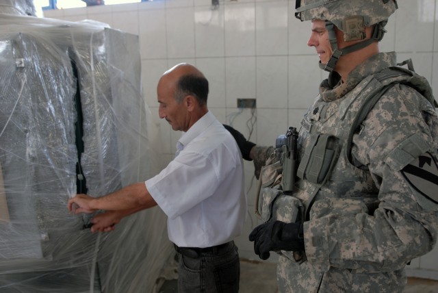 BAGHDAD - "Hopefully this equipment will help the people of Iraq," said Lt. Col. Mark Solomons (right), from Honolulu, Hawaii, the commander of 2nd Battalion, 8th Cavalry Regiment, as he watches Mohammed Mamoud Ahmed, an electrical engineer at Abu Gh...