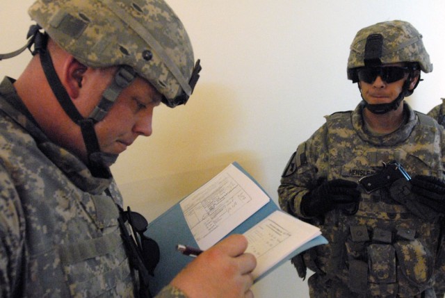 TAJI, Iraq- Whitewater, Wis., native, Staff Sgt. Nicholas Lien (left), the battalion's civil capacity and essential services officer, reviews his checklist with Fairfax, Va., native Maj. Robert Hensley, the battalion executive officer, both...