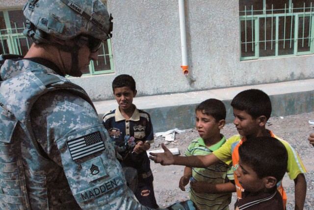 TAJI, Iraq- Cambridge, Mass., native, Staff Sgt. Carlos Madden, a civil affairs team leader assigned to 1479 Civil Affairs Company attached to the 1st Battalion, 82nd Field Artillery Regiment, 1st Brigade Combat Team, 1st Cavalry Division, hands...
