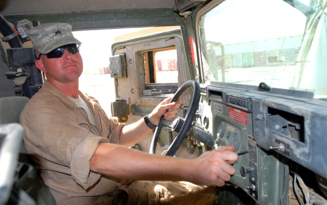 CAMP LIBERTY, Iraq - Sgt. Michael Clark, the quality control quality assurance shop foreman, from Arlington, Texas, assigned to Division Special Troops Battalion, 1st Cavalry Division, demonstrates where the knob is located on an M1114 Humvee in...