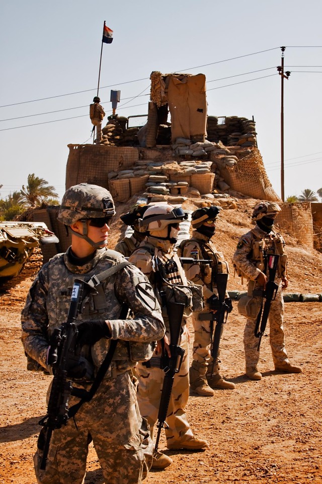 TAJI, Iraq-2nd Lt. Sean Williams (front), from Eatontown, N.J., the officer in charge of a personal security detail for a military transition team,1st Air Cavalry Brigade,1st Cavalry Division, Multi-National Division - Baghdad, stands guard during...