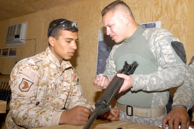 Sgt. Heriberto Fuentes (right), of Bradenton, Fla., shows an Iraqi Soldier how much dirt and debris is in his weapon during a weapon cleaning session at the Warrior Academy, Sept. 16. Fuentes is an infantryman assigned to the Company A, 2nd Battalion...