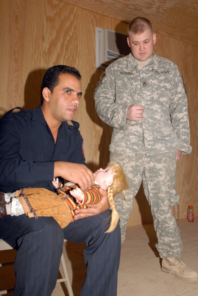 BAGHDAD - Staff Sgt. Chris Howell observes an Iraqi emergency medical technician demonstrate checking and clearing the airway of a small child in respiratory distress, using a baby doll, at a first aid class at Joint Security Station Ur, here,...
