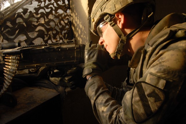 BAGHDAD - Pfc. Jesse Anderson, a combat engineer from Kirksville, Mo., scans his sector from a guard tower at Joint Security Station Ur, here, Sept. 20. Anderson's vantage point gives him a view of the Sadr City area, where he watches for any...