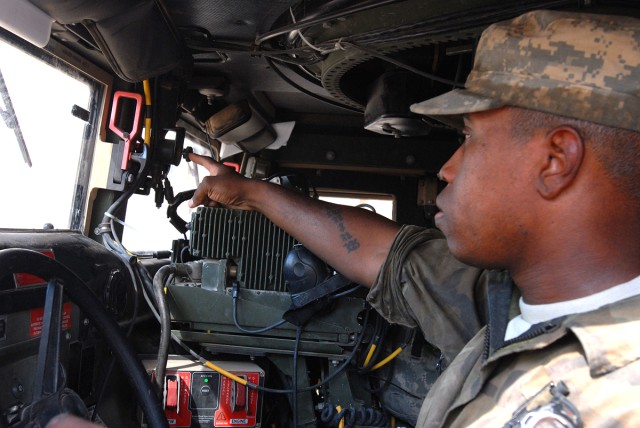 CAMP LIBERTY, Iraq - Spc. Edric Ashley, a light-wheel vehicle mechanic, assigned to quality control and assurance, Division Special Troops Battalion, 1st Cavalry Division, indicates where the switch that activates the windshield wipers is found...