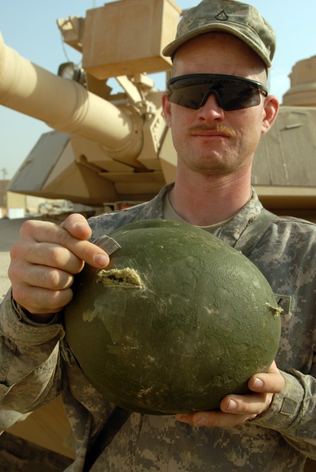 BAGHDAD - Pfc. James Freed, of Odon, Ind., points to the exit hole a bullet made through his helmet when a sniper attacked him while on patrol in the Sadr City area in June. Freed, a tanker assigned to Company A, 2nd Battalion, 5th Cavalry...