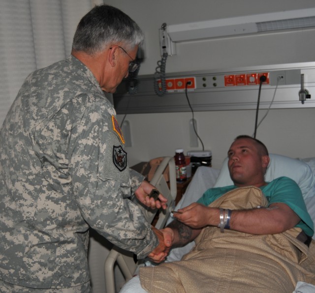 Marine Staff Sgt. Tyler A. Gump receives a coin from Chief of Staff of the Army Gen. George W. Casey Jr.