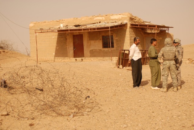 Soldiers from 2nd Brigade Combat Team, 1st Cavalry Division, talk to the Mukhtar of Chemin, Iraq, as they stand outside of the village's old school during an inspection Sept. 8. A new school is being constructed to replace this one, and it will give ...