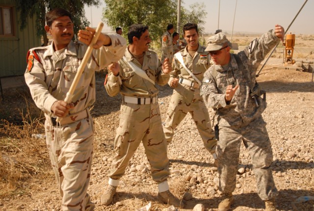Spc. Casey Glass, a Galesburg, Ill., native and a military policeman with 2nd Special Troops Battalion, 2nd Brigade Combat Team, 1st Cavalry Division, shows military policemen with the 12th Iraqi Army Division how to block using a baton during riot c...