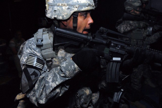 CAMP LIBERTY, Iraq - Staff Sgt. Robert Zulch, of Dickinson, Texas, yells directions to his fellow Soldiers during a combat scenario in the Engagement Skills Trainer at Camp Liberty, here, Sept. 25. Zulch is an infantryman assigned to Company A,...