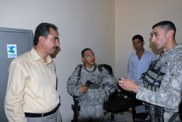 TAJI, Iraq- Cambridge, Mass. native, Staff Sgt. Carlos Madden (right), a civil affairs team leader attached to the 1st Battalion, 82nd Field Artillery Regiment, and Little Rock, Ark. native, Capt. Alex Aquino (middle), commander of Battery B, speak t...