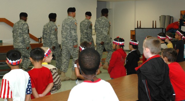 Soldiers of the Rear detachment flag team 15th STB, 15th SB, 13th ESC, perform drill and ceremony for students, family members and faculty at Clarke Elementary School during a ceremony to observe Patriot Day and honor our nations heroes held in the s...