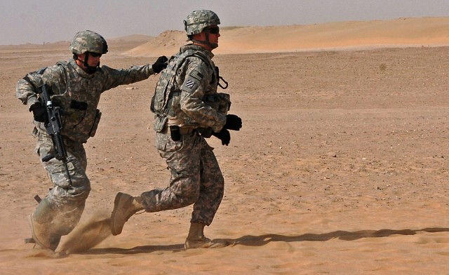 Staff Sgt. Stuart Gimble (left), 15th Sustainment Brigade Personal Security Detachment platoon sergeant and Washington, native, escorts Spc. Charles Caves, 15th PSD Soldier and an Oskaloosa, Iowa, native, to safety during a training exercise here...