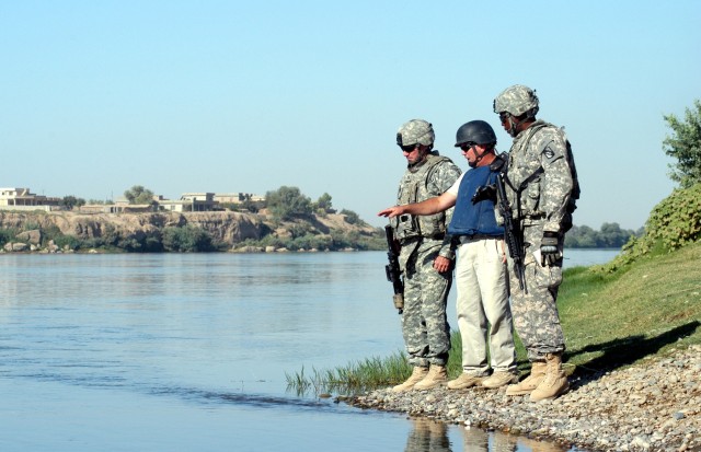 Capt. Drew Clark (left), force protection company commander of Madison, Miss., Buddy B. Winborn (middle), facilities supervisor and native of Alma, Ark., and Capt. James Clark, Water Team officer-in-charge from Clarksville, Tenn., debate the...
