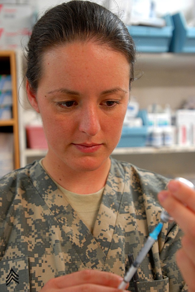 BAGHDAD - Sgt. Janelle Graham, a health care specialist from Sacramento, Calif., fills a syringe with flu vaccination at the Battalion Aid Station, on Camp Liberty, Oct. 1.  The vaccination is an inactive virus, said Graham, with Headquarters Support...