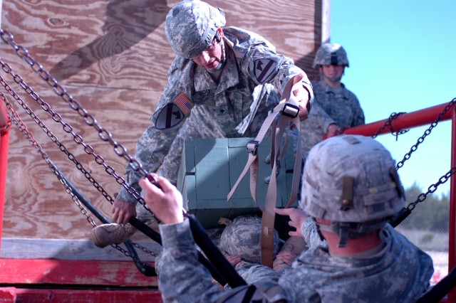 Spc. Richard Root, a Cannon Crewmember with 5th Battalion 82nd Field Artillery Regiment, 4th Brigade Combat Team, 1st Cavalry Division, pass an ammunition box across a human bridge made of Pfc. Micheal Watson, (Bottom back) a Cannon Crewmember,...