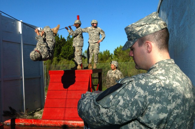 1st Lt. Mike Munroe, a grader with 5th Battalion 82nd Field Artillery Regiment, 4th Brigade Combat Team, 1st Cavalry Division, monitored the time as Spc. Vincent Stringer, a Cannon Crewmember, assigned to 5-82FA, pulls himself across a high wire...