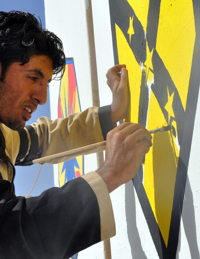 Qaysar Adnan, an Iraqi painter, puts the 15th Sustainment Brigade patch onto one of the walls surrounding the brigade's headquarters here Oct. 5 moments after a transfer of authority ceremony. (U.S. Army photo by Sgt. Matthew C. Cooley, 15th...