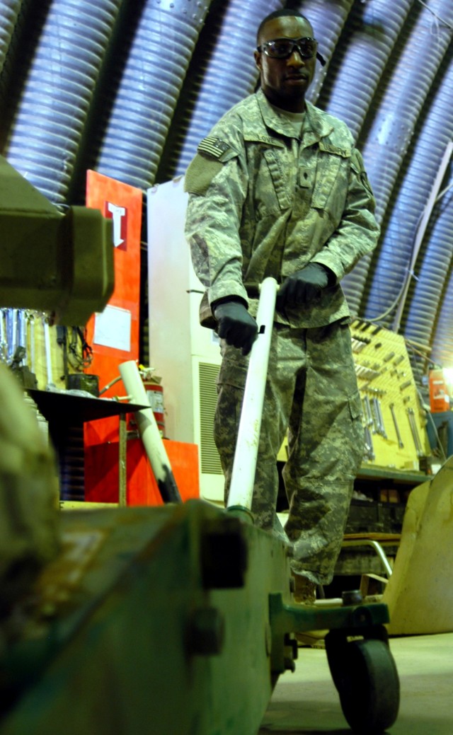 Spc. Cornelius C. Love, a mechanic from Tutwiler, Miss., pulls a 20-ton floor jack from beneath an MRAP truck after helping to replace the front shocks Sept. 30. Love serves with C Company, 2nd Battalion, 198th Combined Arms, Mississippi Army...