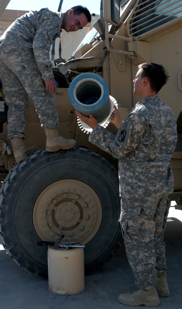 Spc. Andrew Willard (left), a driver from Belzoni, Miss., and Spc. Stephen Maevers, a gunner from Clarksdale, Miss., replace an air filter in their MRAP while conducting preventative maintenance, checks, and services Sept. 30.  Both serve with 3rd...