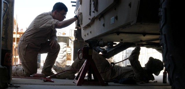 Sgt. John D. Pumphrey (left), a truck commander from Columbus, Miss., uses his time-off to help Sgt. David A. McDonald, a mechanic from Coldwater, Miss., replace the rear brakes on his High Mobility, Multipurpose Vehicle, Sept. 30.  Both are...