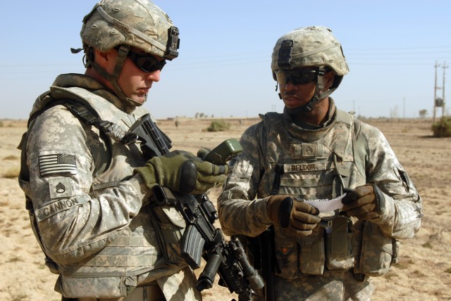 TAJI, Iraq - Staff Sgt. William Cannon (left), of Taylor, Mich., and Sgt. Jhonny Beldor, of Fredericksburg, Pa., confer about directions during a patrol near Taji Oct. 5. Both non-commissioned officers are artillerymen assigned to Company A, 1st...