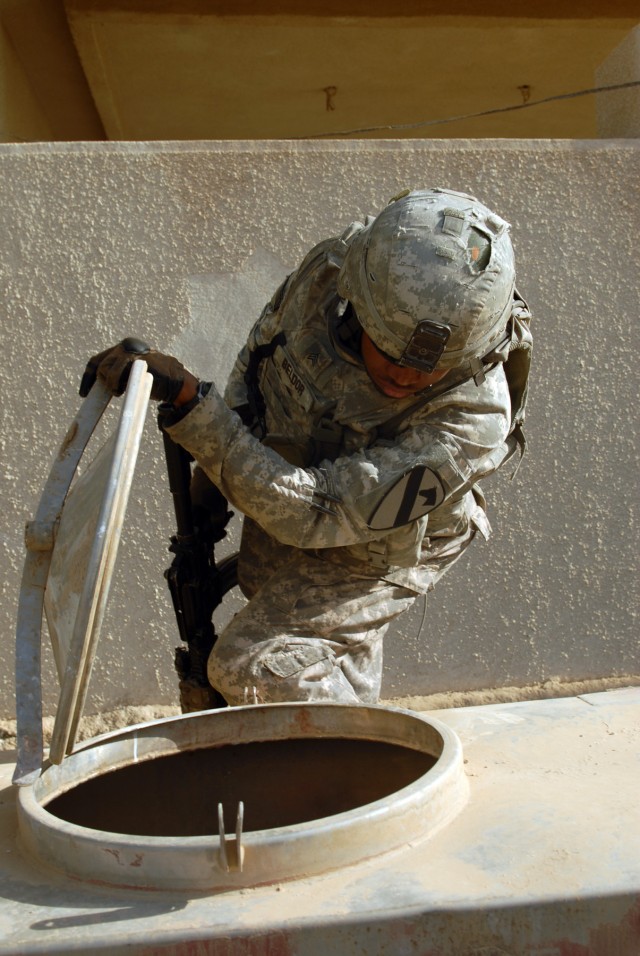 TAJI, Iraq -Sgt. Jhonny Beldor, an artilleryman from Fredericksburg, Pa., searches for weapons during a joint patrol with the Iraqi Army in the Taji area, Oct. 5. "I like the excitement when we get to do stuff like this instead of just sitting on...
