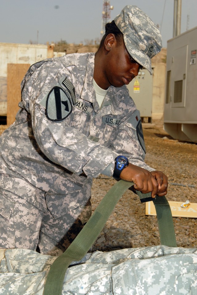 CAMP LIBERTY - Pfc. Kamella Givans, of West Palm Beach, Fla., fastens a strap around a Soldier acting as an injured patient on a litter during ambulance evacuation training, here, Oct. 9. Givans is a supply specialist assigned to Company A, Division ...