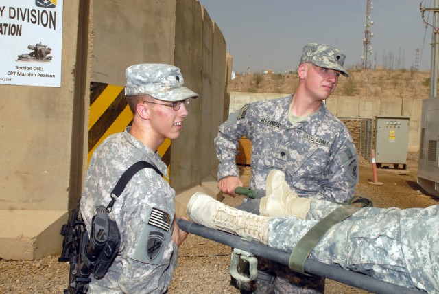 CAMP LIBERTY - Spc. Christopher Myers (left), of Lowell, Ark., and Spc. Christopher Alexander, of Alma, Ark., load a litter onto an ambulance outside the Division Special Troops Battalion aid station, here, Oct. 9. Both Soldiers, who are assigned to ...