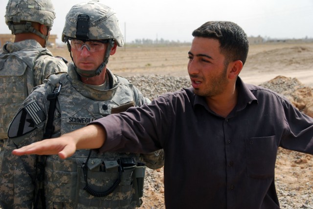 TAJI, Iraq- Ozark, Ala. native, Lt. Col. Eric Schwegler (left), commander of the 1st Battalion, 82nd Field Artillery Regiment, 1st Brigade Combat Team, 1st Cavalry Division, listens as the Odessa Bridge project's site manager explains the work...
