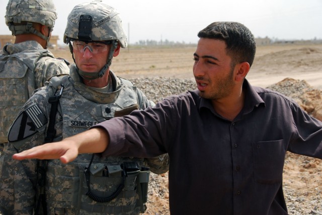 TAJI, Iraq- Ozark, Ala. native, Lt. Col. Eric Schwegler (left), commander of the 1st Battalion, 82nd Field Artillery Regiment, 1st Brigade Combat Team, 1st Cavalry Division, listens as the Odessa Bridge project's site manager explains the work that h...