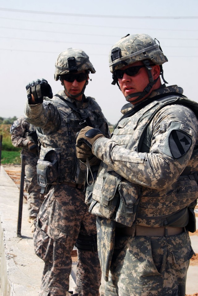 TAJI, Iraq- Cambridge, Mass. native, Staff Sgt. Carlos Madden (left), a civil affairs team leader, speaks with Whitewater, Wis. native, Staff Sgt. Nicholas Lien, the battalion civil capacity and essential services officer, during an assessment of the...