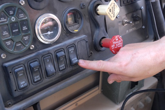 BAGHDAD- Sgt. Abraham Kay, a motor pool maintenance squad leader, from Coleman, Texas, points to the transfer range switch in a Mine-Resistant Ambush-Protected vehicle, here, Oct. 12.  In order to put an MRAP vehicle into four-wheel drive, set the...