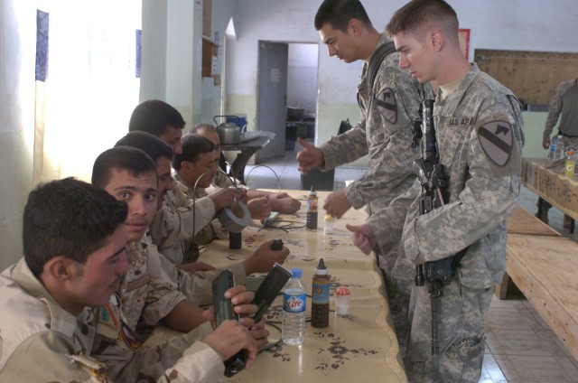Soldiers from Echo Company, 1st Battalion, 8th Cavalry Regiment, train Iraqi Army soldiers during the classroom portion of a training course held on Forward Operating Base Warrior, Kirkuk, Iraq, Oct. 6. The class introduced military demolitions...
