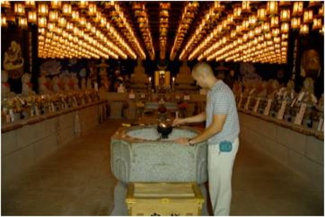 A 441st MI Bn Soldier burns incense in a Buddhist temple.