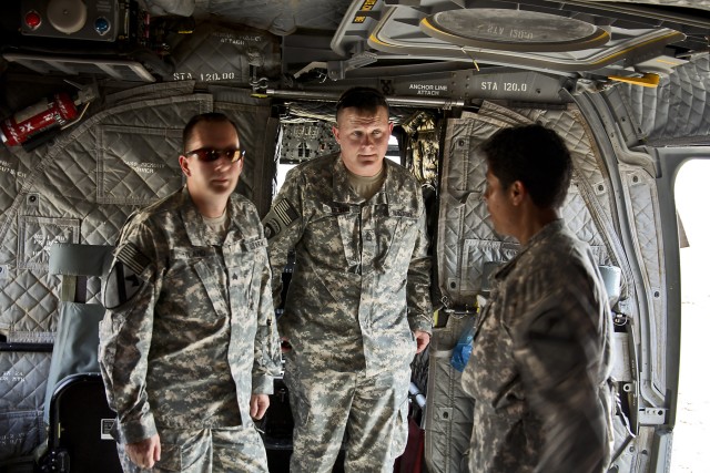 CAMP TAJI, Iraq-During a return trip to Iraq as a part of Operation Proper Exit, Sgt. John Hyland (left) and Sgt. 1st Class Joshua Olson (center), get a tour of a CH-47F Chinook helicopter by Josia Ortiz (right), a crew chief in Company B, 2nd...