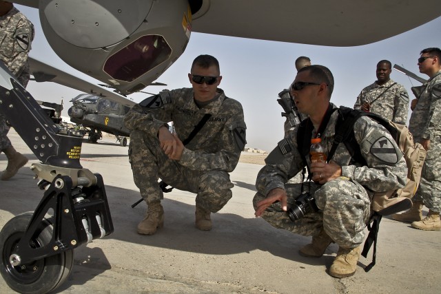 CAMP TAJI, Iraq-Spc. Josh Palowitch (left), from Grayson, Ky., a Sky Warrior opperator for Quick Reaction Capabiltiy 1, 1st ACB,  talks with retired Cpl. Craig Chavez (right) about the capabilities of the aircraft, here, Oct. 13. Chavez was...