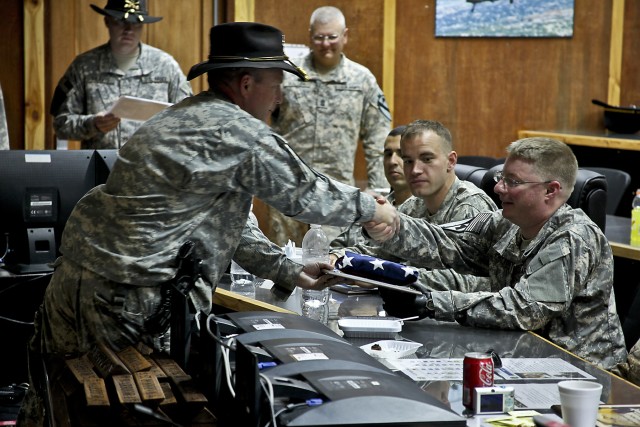 CAMP TAJI, Iraq-To show appreciation for his sacrifices, Col. Douglas Gabram, from Clevland Ohio, commander of the 1st ACB, presents a flag which was flown over Baghdad in an AH-64D Apache attack helicopter, to retired Sgt. Ethan Payton. Payton,...