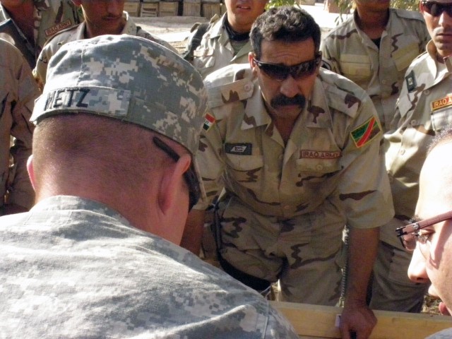 CAMP TAJI, Iraq- Baltimore native, Staff Sgt. Joseph Metz (foreground), a squad leader assigned to the 1st Battalion, 82nd Field Artillery Regiment, 1st Brigade Combat Team, 1st Cavalry Division, watches as Soldiers of the 37th Brigade, 9th Iraqi Arm...