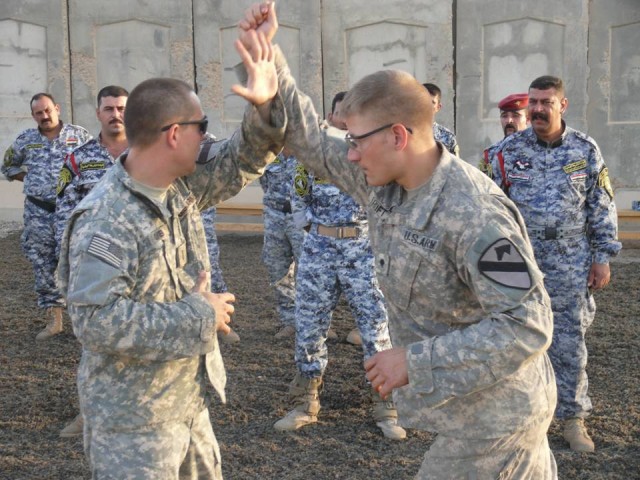 BAGHDAD-San Benito, Tex. native, 1st Lt. Mike Olvera (left), uses his forearm to block Plant City Fla. native, Spc. David Croft's simulated knife attack during combined combatives training with their Iraqi partners at Joint Security Station Istiqlal,...