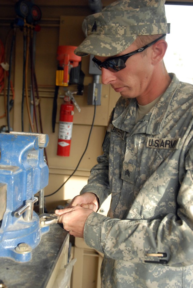 BAGHDAD - Fultondale, Ala. native, Sgt. Jason Leatherwood, a Bradley mechanic assigned to Company B, 2nd Battalion, 5th Cavalry Regiment, 1st Brigade Combat Team, 1st Cavalry Division, screws a vice back onto its platform after performing...