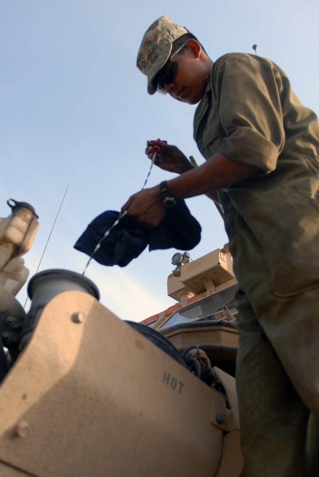 BAGHDAD - San Antonio native, Pfc. Adolfo Hernandez, a Bradley mechanic assigned to Company B, 2nd Battalion, 5th Cavalry Regiment, 1st Brigade Combat Team, 1st Cavalry Division, checks the engine oil of a Mine-Resistant Ambush-Protected Vehicle...