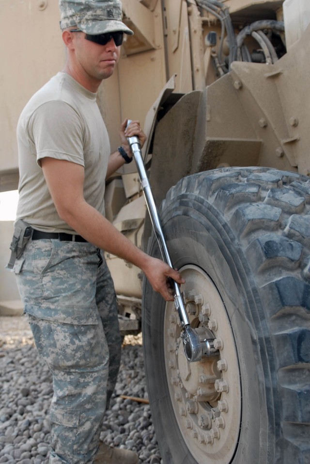 BAGHDAD - Pasco, Wash. native, Sgt. Luke Mehling, a tank mechanic assigned to Company B, 2nd Battalion, 5th Cavalry Regiment, 1st Brigade Combat Team, 1st Cavalry Division, tightens a bolt after replacing a tire on a Mine-Resistant...