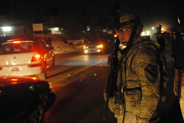 BAGHDAD - Sgt. Aron Stanley, a tanker from Snyder, Texas, assigned to Company C, 2nd Battalion, 5th Cavalry Regiment, 1st Brigade Combat Team, 1st Cavalry Division, waits for traffic before crossing during a joint patrol to prevent insurgents from...