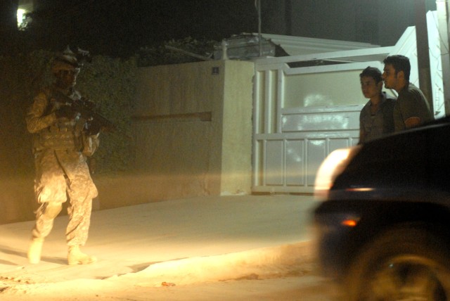 BAGHDAD - On his third tour to Baghdad, Sgt. Steven Barner, a tank gunner from Greenwood, Miss., assigned to Company C, 2nd Battalion, 5th Cavalry Regiment, 1st Brigade Combat Team, 1st Cavalry Division, patrols the night while two Iraqi teenagers...